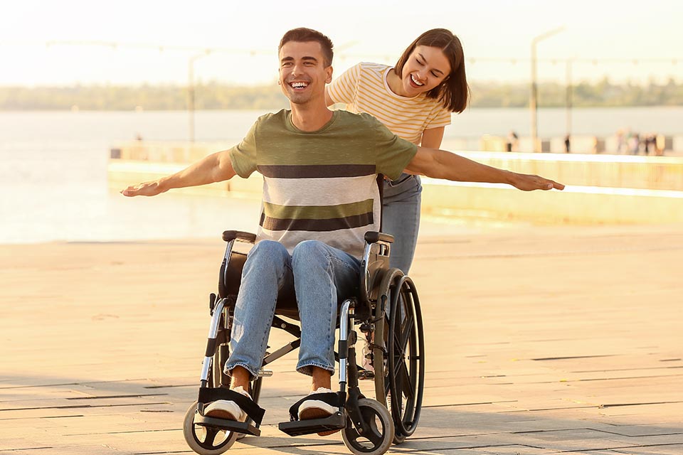 Young man with physical disability and his wife outdoors